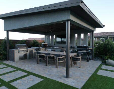 A patio with an outdoor grill and table